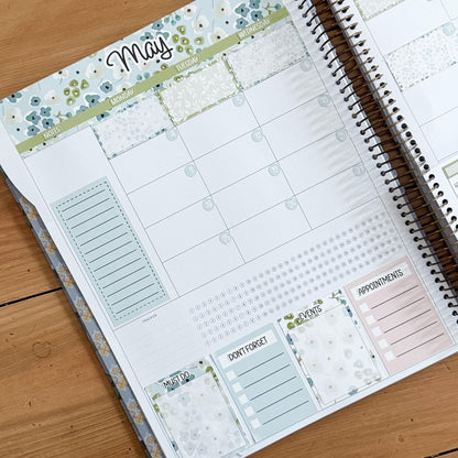 a spiral-bound notebook with a calendar page and various sections for planning and organizing tasks.