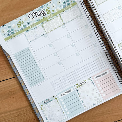 a spiral-bound notebook with a calendar page and various sections for planning and organizing tasks.