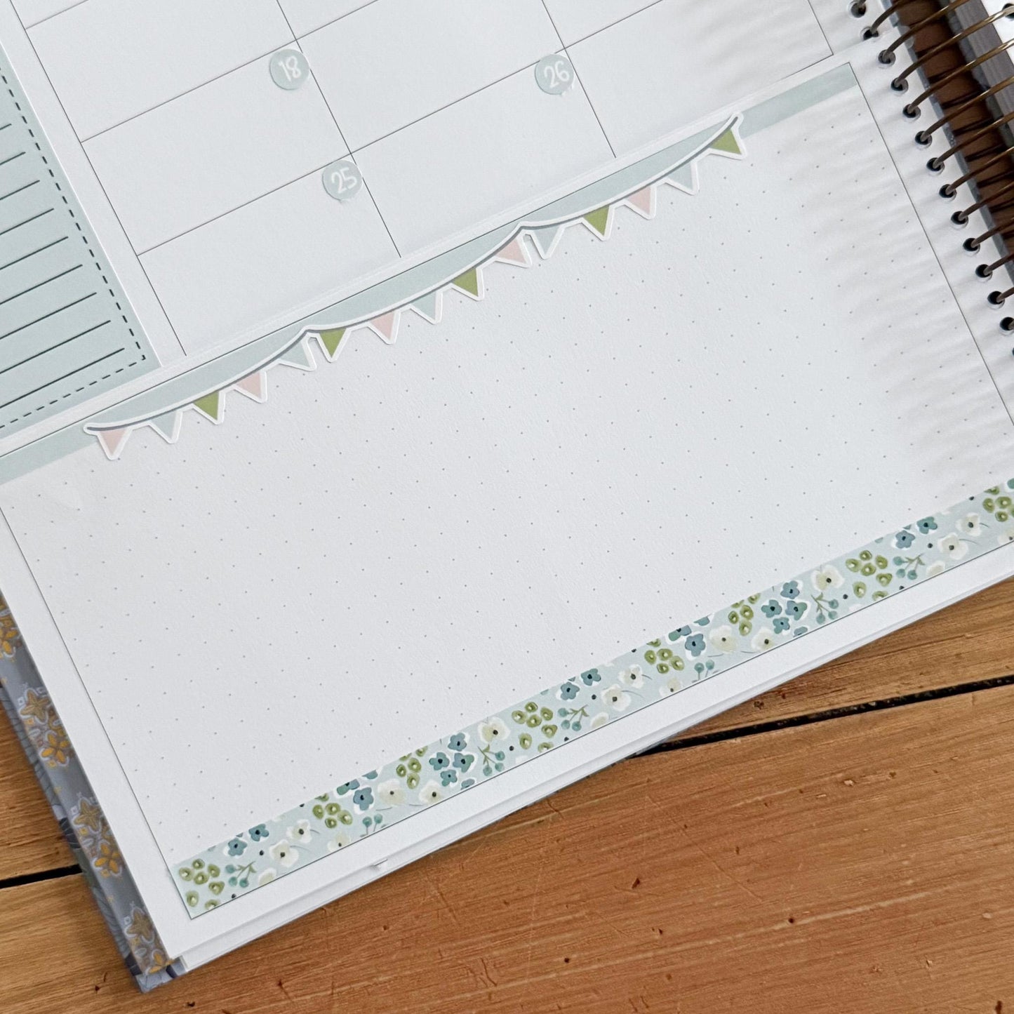 a notebook with a blank page, a decorative border, and a spiral binding.
